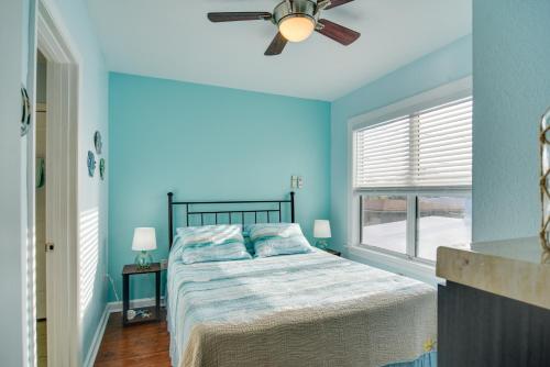 a blue bedroom with a bed and a ceiling fan at Walk to Madeira Beach Family Resort Condo in St Pete Beach