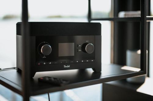 a black computer speaker sitting on a shelf at Hausboot Red Pearl in Zehdenick
