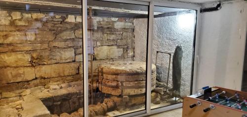 Cette chambre est dotée d'un mur en pierre et d'une fenêtre en verre. dans l'établissement Moulin de Saint Gely, à Salvagnac-Saint-Loup