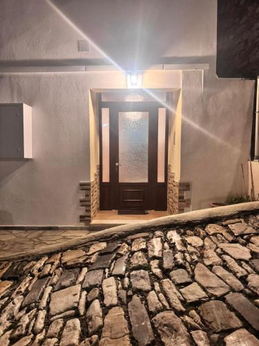 a door in a building with a stone floor at Milies Creekside Studio in Miléai