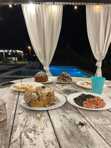 a table with several plates of food on it at Quinta La Deseada Brandsen in Estación Coronel Brandsen
