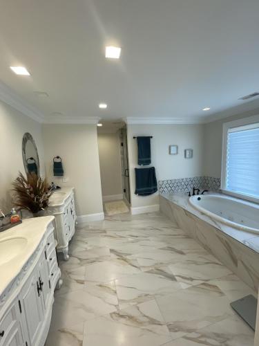 a large bathroom with a tub and a sink at 8 Sea Front, Oceanfront Estate, Pool, Game Room, Elevator in Hilton Head Island