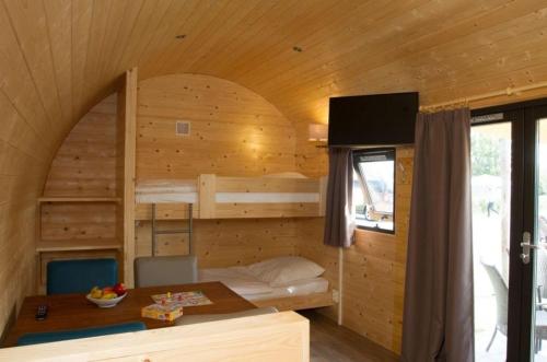 ein Schlafzimmer mit Etagenbetten in einer Holzhütte in der Unterkunft Kleine Nordseewelle ohne Hund in Norden