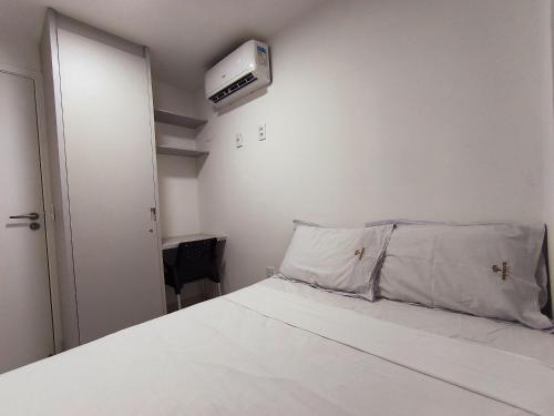 a small bedroom with a bed and a air conditioner at Ap 2Q Beira-Mar ao lado do Food Park Cabo Branco in João Pessoa