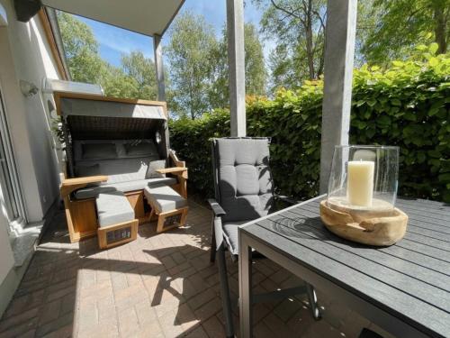 a patio with a table and chairs and a candle at Ferienwohnung Kleine Auszeit in Neuhaus