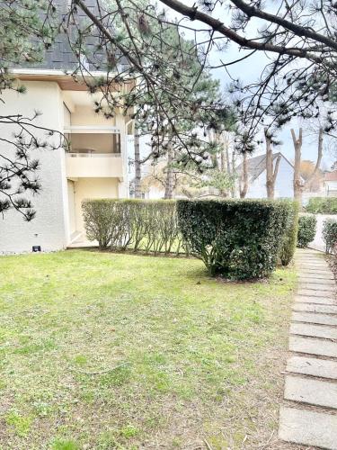 une maison avec une haie dans la cour dans l'établissement Studio 4 people Stella beach, à Cucq