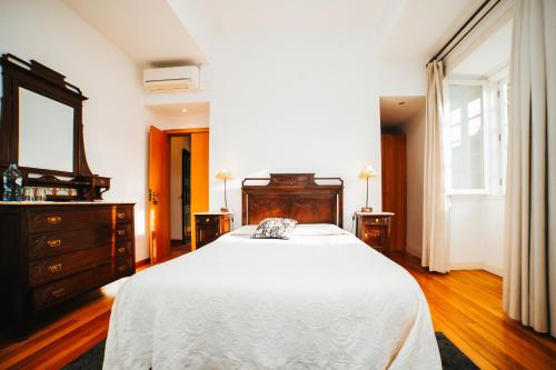 a bedroom with a bed and a dresser and a mirror at Quarto Duplo com Jardim e Piscina in Póvoa de Lanhoso