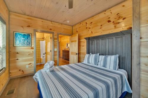 a bedroom with a bed in a room with wooden walls at Honeybear Hideaways - Luxury Gatlinburg Smoky Cabin with Indoor Pool and Hot Tub in Gatlinburg