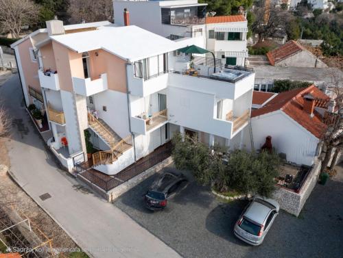 an aerial view of a house with two cars parked in a parking lot at Apartman Štorija in Brela