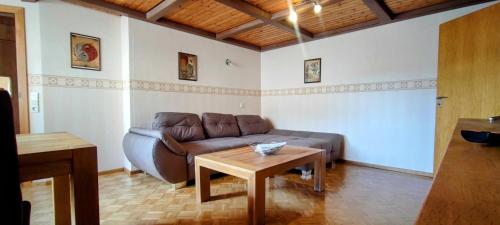 a living room with a brown couch and a table at FeWo Bergenrot Urlaub mit Hund in Arnsberg