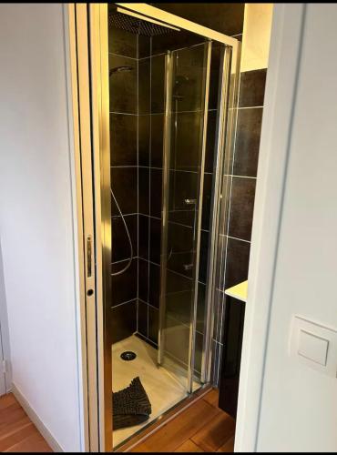 Cette chambre dispose d'une porte de douche en verre. dans l'établissement Vivez la magie de Carnac au coeur des alignements, à Carnac