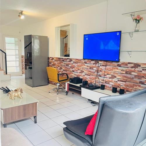 a living room with a tv on a brick wall at Royal Classic Apartments in Durban