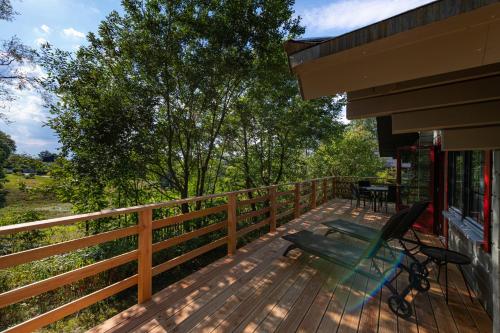 a deck with a chair on the side of a house at Alm-Lodge 2 in Clausthal-Zellerfeld