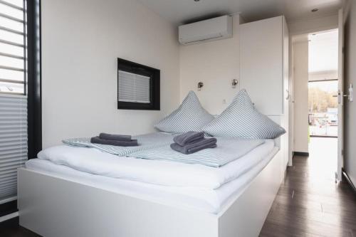 een wit bed met handdoeken in een kamer bij Hausboot Paradise - LP9 in Peenemünde