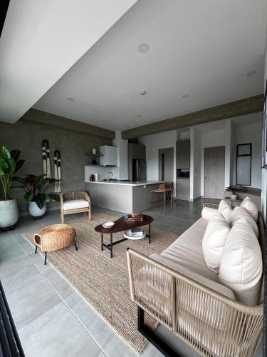a living room with a white couch and a kitchen at Tropicalia Home - Apartment in Armenia