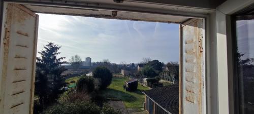 une fenêtre ouverte avec vue sur un champ dans l'établissement Le bouf tard chambre vue sur jardin CH7, à Vendôme