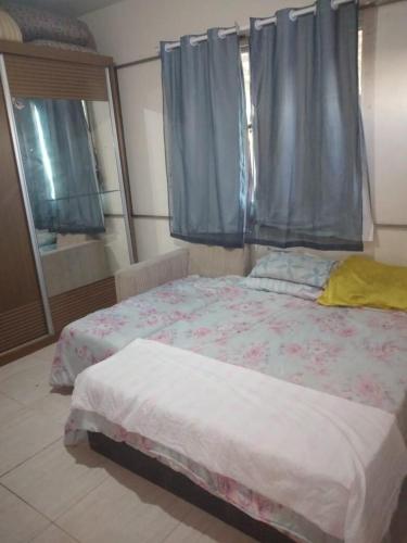 a bedroom with a bed and a window with blue curtains at Alugo para Carnaval in Araruama