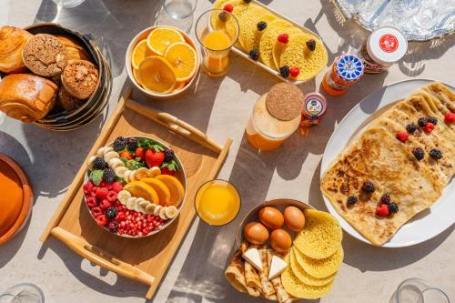 a table full of breakfast foods and orange juice at Villa Marrakech, 15 min from center, Disco, Hammam in Marrakesh