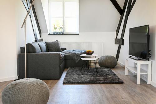 una sala de estar con un sofá y una mesa en Seen-Apartment im Herrenhaus Rheinblick, en Xanten