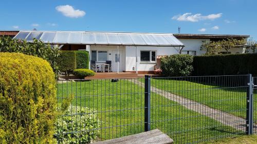 a house with a fence in front of a yard at Am Ufersteig-I in Verchen