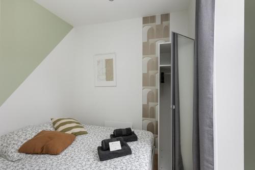 une chambre avec un lit et un miroir dans l'établissement Le Vigilant, à Brest