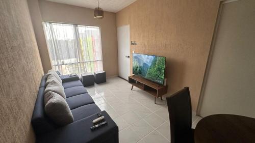 a living room with a blue couch and a flat screen tv at Cancun con la calidez de casa in Cancún