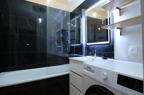 une salle de bain avec un lavabo et une machine à laver dans l'établissement Le Mistral - Calme et Climatisé - Hypercentre - Terrasse - Wifi, à Avignon