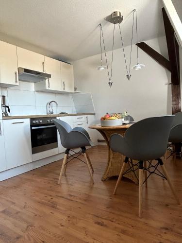 a kitchen with a table and chairs in a room at Ferienwohnung Nord in Fehmarn