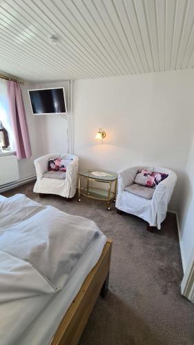 a room with two beds and a table and a tv at Appartement Nummer 26 in Kappeln