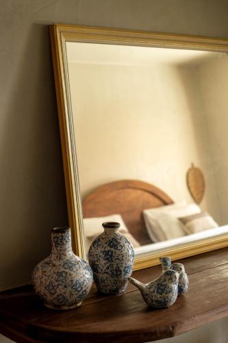 three vases sitting on a shelf in front of a mirror at Benção Hotel in Morro de São Paulo