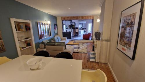 un salon avec une table et des chaises blanches dans l'établissement Hypercentre - suite parentale et grande terrasse, à Albi