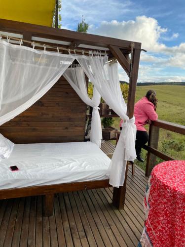 Eine Frau macht ein Bett auf einem Deck in der Unterkunft Vale de cambara II in Cambará