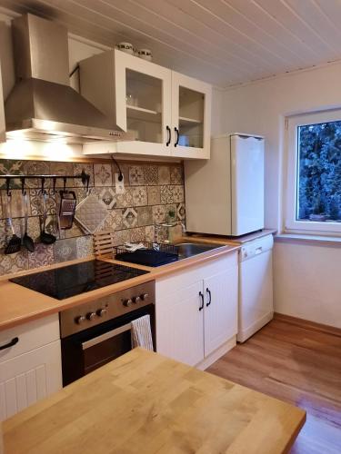 a kitchen with white cabinets and a white refrigerator at Ferienwohnung "Wiesensee" im historischen Landhaus in Pottum