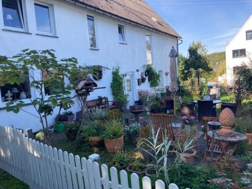 a garden in front of a white house at Ferienwohnung "Wiesensee" im historischen Landhaus in Pottum
