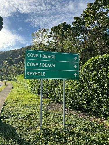 a green street sign on the side of a road at A tranquil ocean view condo, private beach in Boracay