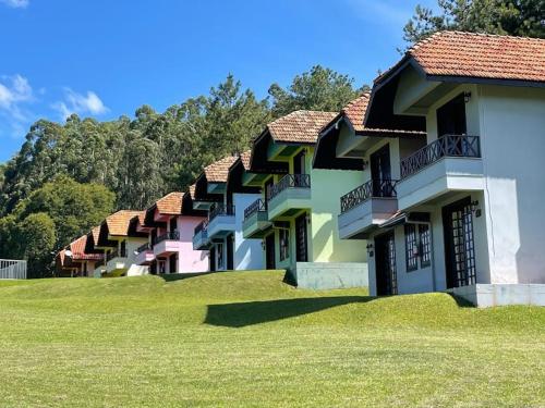 a row of houses on a hill with grass at Fazenda do Engenho Parque Hotel in Piratuba