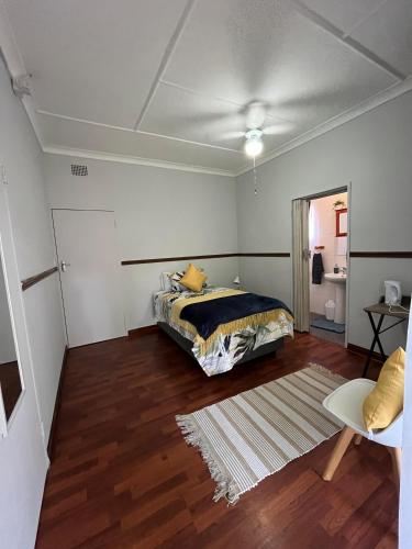 a bedroom with a bed and a rug at Tanya's Haven Guesthouse in Klerksdorp