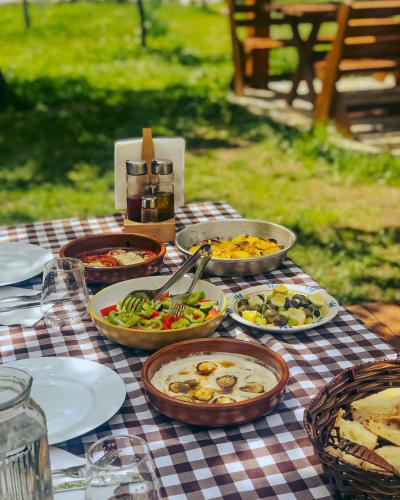 a table with bowls of food on a checkered table cloth at Logu i Harushave in Theth