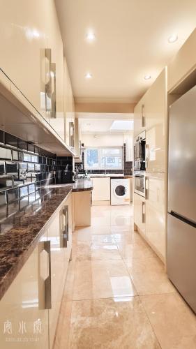 a large kitchen with stainless steel appliances at The Fairway Garden in South Ruislip Station