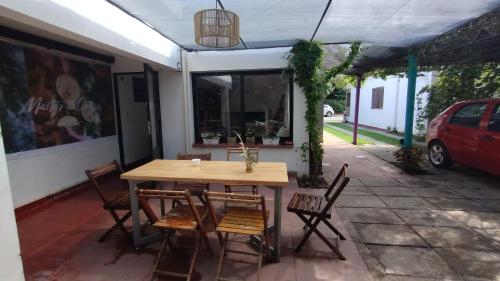 een houten tafel en stoelen op een terras bij Gen Viajero Hostel in Merlo