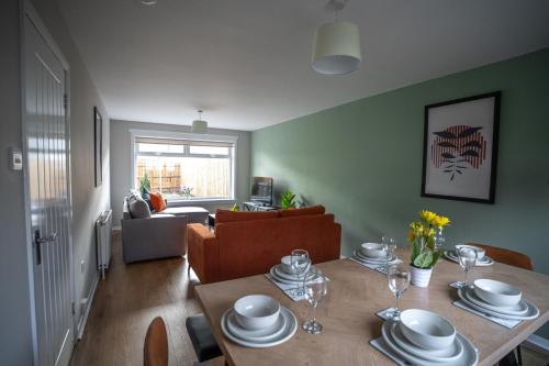 a dining room with a table and a living room at Bank House in Livingston
