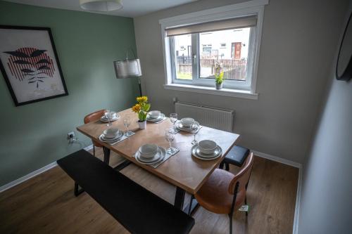 a dining room table with chairs and a window at Bank House in Livingston