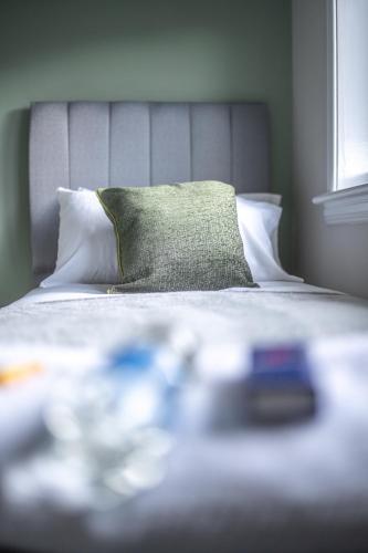 a bedroom with a bed with a green pillow at Bank House in Livingston