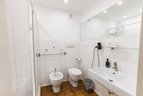 a white bathroom with a toilet and a sink at casa dolce casa in Rome