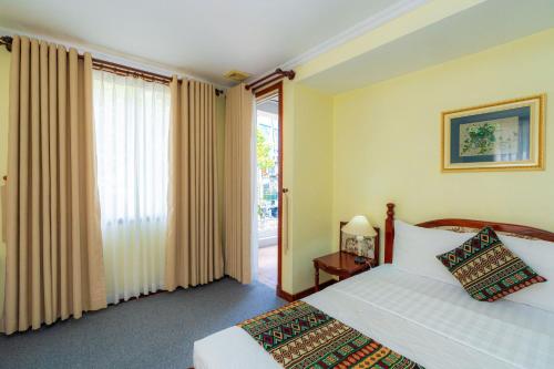 a bedroom with two beds and a large window at Hoang Ha Boutique Hotel in Ho Chi Minh City