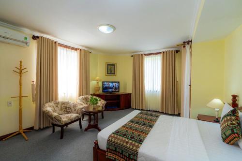 a hotel room with a bed and a chair at Hoang Ha Boutique Hotel in Ho Chi Minh City