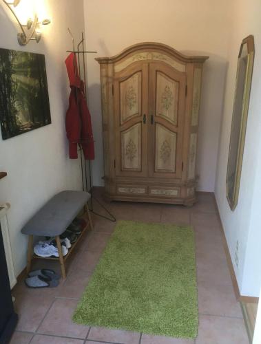 a room with a wooden cabinet and a green rug at Ferienhaus Feder in Lichtenau