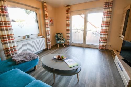 a living room with a blue couch and a table at Familienhof Brüning - Ferienwohnung Hofblick in Meppen