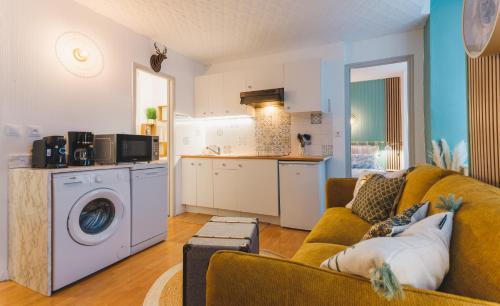 a living room with a couch and a kitchen at Le Flocon Doré in Cauterets