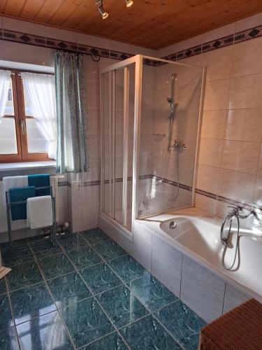 a bathroom with a bath tub and a shower at Beim Grafen in Frasdorf